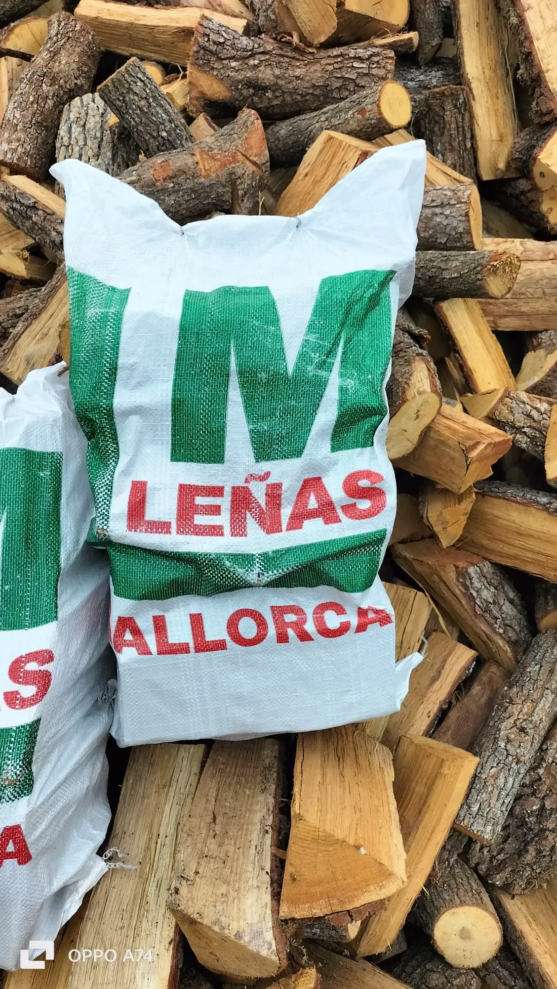 Brennholzsack von Leñas Mallorca auf einem Eichenholzstapel